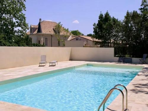 - une piscine avec 2 chaises en face d'une maison dans l'établissement Harmony - Cosy villa in the south of France, à Lézignan-la-Cèbe