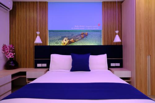 a bedroom with a large bed and a large screen at Victoria City Hotel in Oranjestad