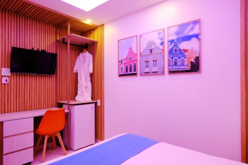 a room with a bed and a television and a statue at Victoria City Hotel in Oranjestad