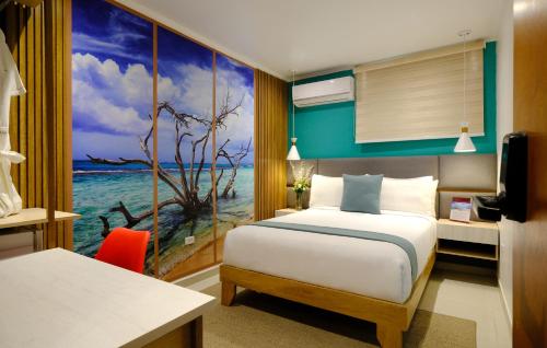 a hotel room with a bed and a view of the ocean at Victoria City Hotel in Oranjestad