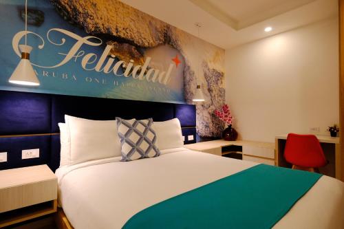 a hotel room with a bed and a sign on the wall at Victoria City Hotel in Oranjestad