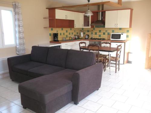 un salon et une cuisine avec un canapé et une table dans l'établissement Gite 2min de Saumur, à Saumur