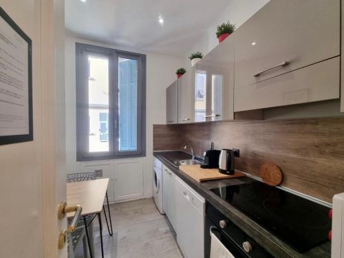 une cuisine avec des armoires blanches et un comptoir dans l'établissement Villa BRIGITTE MONACO Parking et Terasse, à Beausoleil