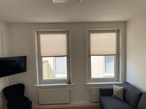 a living room with two windows and a couch at Altstadtinsel am Johanneum 22 in Lübeck