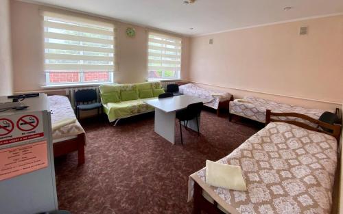 a room with beds and a couch and a table at Tian-Shan Guest House in Balykchy