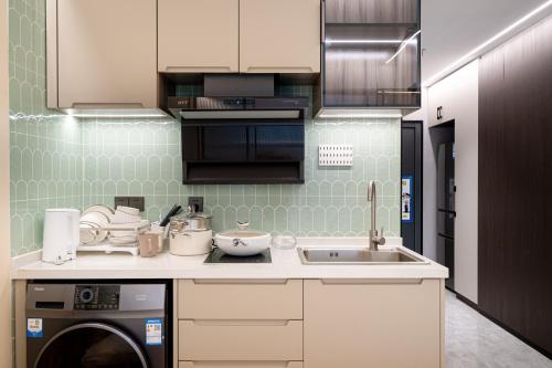 a kitchen with a sink and a washing machine at Today Aparthotel West Lujiazui Shanghai in Shanghai