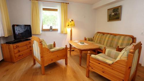 a living room with a couch and a table and a tv at Ferienhaus-Winzerhaus Sasbach in Sasbach am Kaiserstuhl