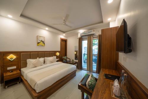 a bedroom with a large bed and a television at Perfectstayz Premium Mystic falls with Rooftop Pool & Cafe in Narendranagar