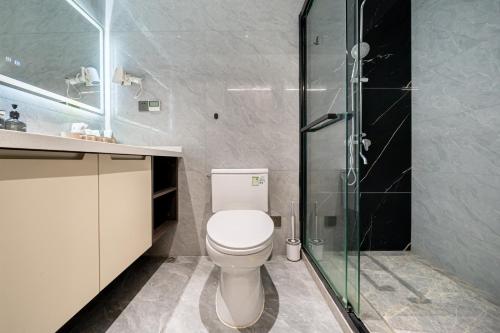 a bathroom with a toilet and a glass shower at Today Aparthotel West Lujiazui Shanghai in Shanghai
