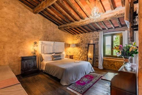 a bedroom with a large bed and a window at B&B Podere Camaiano in Roccastrada