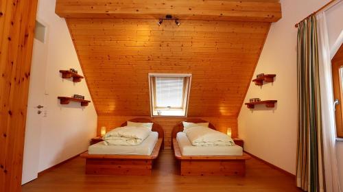 two beds in a small room with a window at Ferienhaus-Winzerhaus Sasbach in Sasbach am Kaiserstuhl