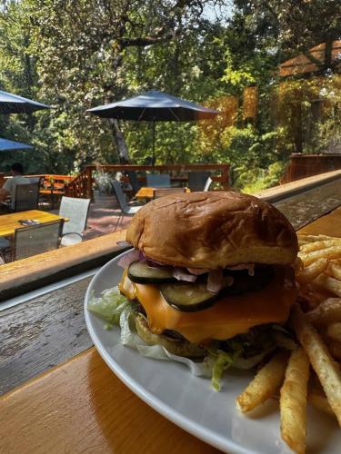 a plate with a hamburger and french fries on a table at The Lindsay Lodge in Applegate