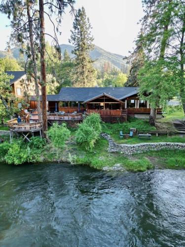 a house next to a river with a lodge at The Lindsay Lodge in Applegate