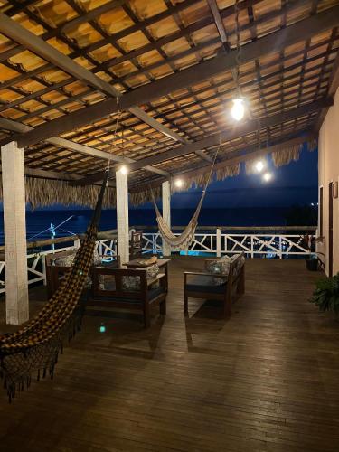 a porch with a hammock and a view of the ocean at Villa Caravelas Praia de Moitas in Amontada