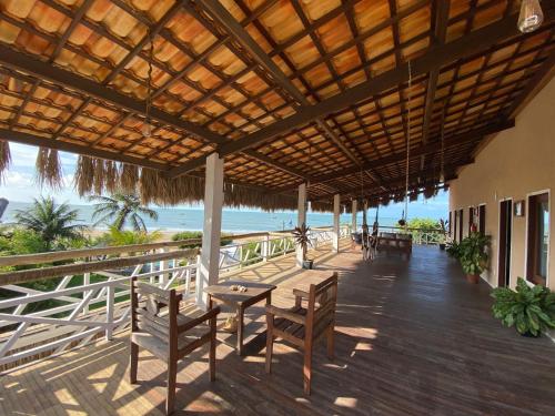a patio with a table and chairs and the ocean at Villa Caravelas Praia de Moitas in Amontada