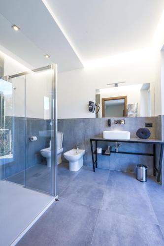 a bathroom with a shower and a sink and a toilet at Hotel Vita in Salò
