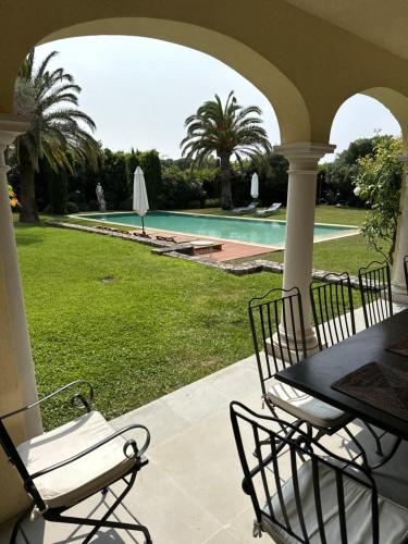 un patio avec une table et des chaises à côté d'une piscine dans l'établissement Villa Belle Isnarde, à La Celle-sous-Gouzon