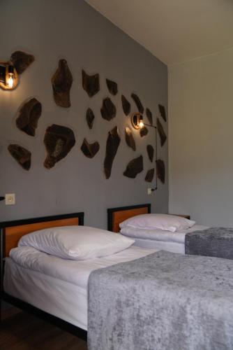 two beds in a room with rocks on the wall at Hotel Hobbiton near Vardzia Caves in T'mogvi