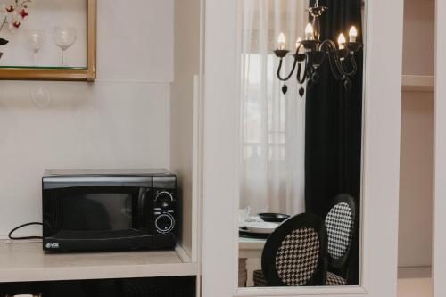 a microwave sitting on a counter next to a table at PLAN Deluxe Hydro Suite Niš, centar, free parking in Niš