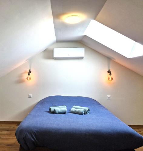 a bedroom with a blue bed with two pillows at Appartement 3 chambres in Montceau-les-Mines