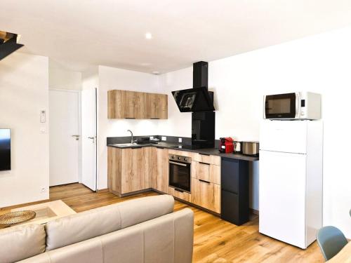 a living room with a couch and a kitchen at Appartement 3 chambres in Montceau-les-Mines