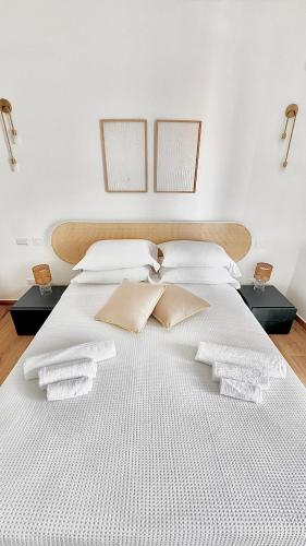 a large white bed with white towels on it at Aptments2 - real estate solutions in Olbia