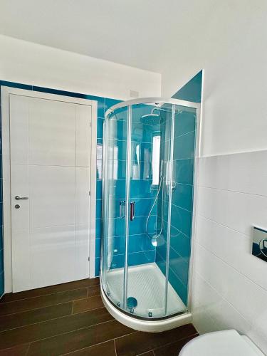a bathroom with a shower with a glass door at Aptments2 - real estate solutions in Olbia