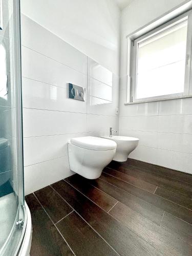 a bathroom with a toilet and a sink and a window at Aptments2 - real estate solutions in Olbia
