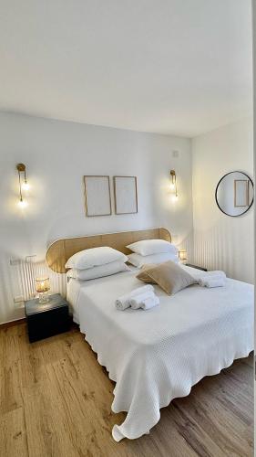 a white bedroom with two beds and two lamps at Aptments2 - real estate solutions in Olbia