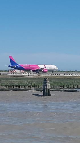 an airplane is on the runway at an airport at Fly to Venice Airport View locazione turistica in Venice
