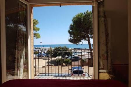 an open door to a patio with a view of the beach at Cap Corse-Santa Severa, grande appartamento vista mare in Luri