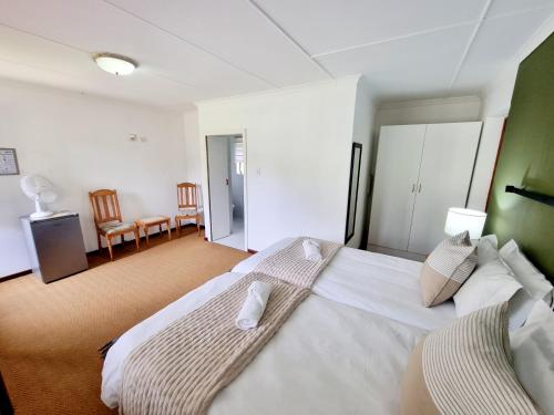 a bedroom with a large white bed in a room at Farmlands Guesthouse in George