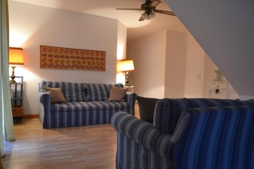 a living room with two couches and a ceiling fan at Cap Corse-Santa Severa, grande appartamento vista mare in Luri