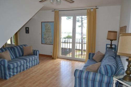 - un salon avec deux canapés bleus et une porte coulissante en verre dans l'établissement Cap Corse-Santa Severa, grande appartamento vista mare, à Luri