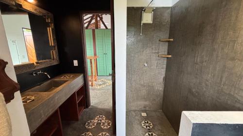 two images of a bathroom with a sink and a mirror at Apartamento do Manu in Atins
