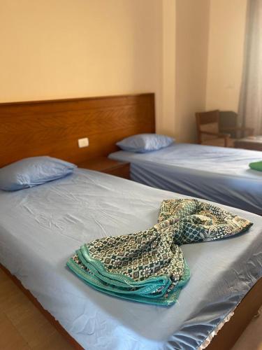 a hotel room with two beds with towels on them at قريه اكوا فيو - الساحل الشمالى - الكيلو91 in Dawwār Abū Maḩrūs
