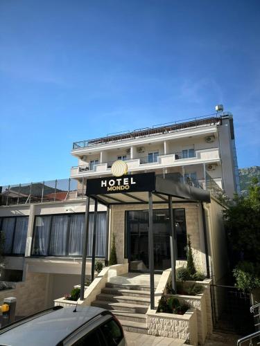 a hotel with a sign in front of a building at Hotel Mondo in Budva