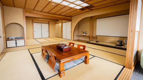 a large room with a table and a screen at 熱海の隠れ里 in Atami