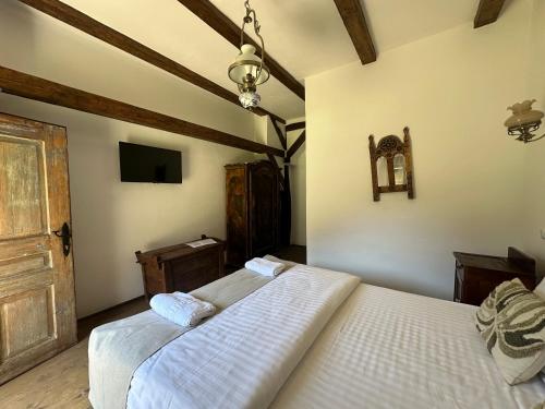 a bedroom with two white beds and a tv at Castle View Saschiz - Traditional Guesthouse in Saschiz