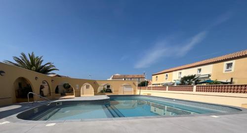 une piscine devant un immeuble dans l'établissement T2 lumineux plage et piscine, à Frontignan