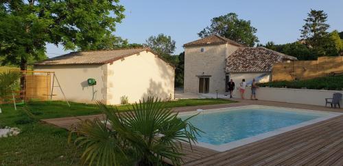 une maison avec une piscine dans une cour dans l'établissement Bienvenue A la Grange de Tatie 4 chambres, à Courbiac