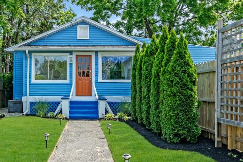 ein blaues Haus mit einer roten Tür und einem Zaun in der Unterkunft Bungalow Blue in Bradley Park in Neptune City