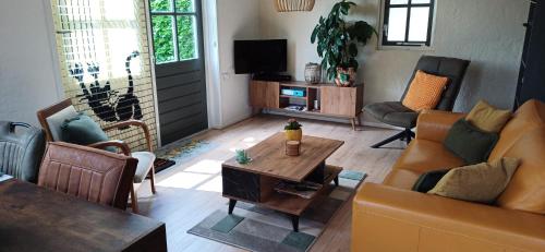 a living room with a couch and a table at Bed & Breakfast Appenseweg in Voorst