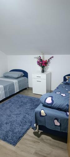 a bedroom with two beds and a vase of flowers at Vila Hakim in Ilidza