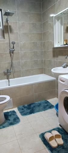 a bathroom with a tub and a toilet and two rugs at Vila Hakim in Ilidza