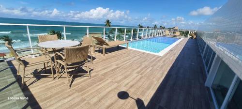 a balcony with a table and chairs and a swimming pool at Studio Al Mare - Ocean Blue in Porto De Galinhas