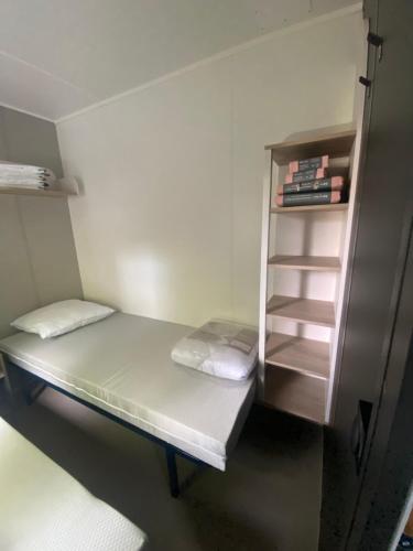 Cette petite chambre comprend un lit et une étagère. dans l'établissement Mobil home plage 4 étoiles, à Fréjus