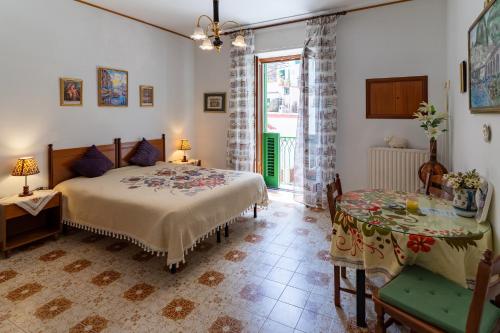 a bedroom with a bed and a table and a window at CristallPont Amalfi Day in Atrani