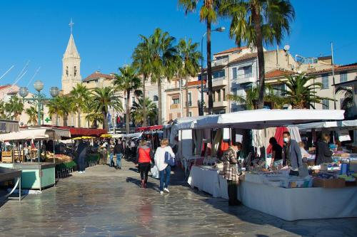 Un groupe de personnes se promenant autour d'un marché en plein air dans l'établissement Les Pins de la Mer, à Sanary-sur-Mer