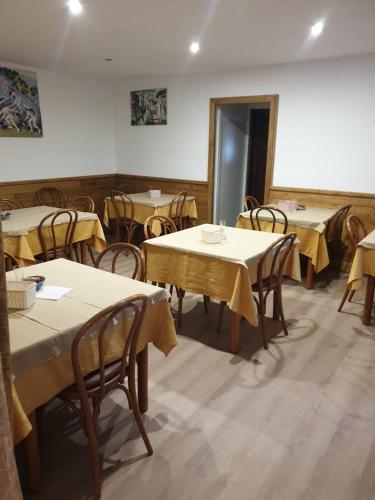 a dining room with tables and chairs with yellow table cloth at Claudia B&B in Pescasseroli